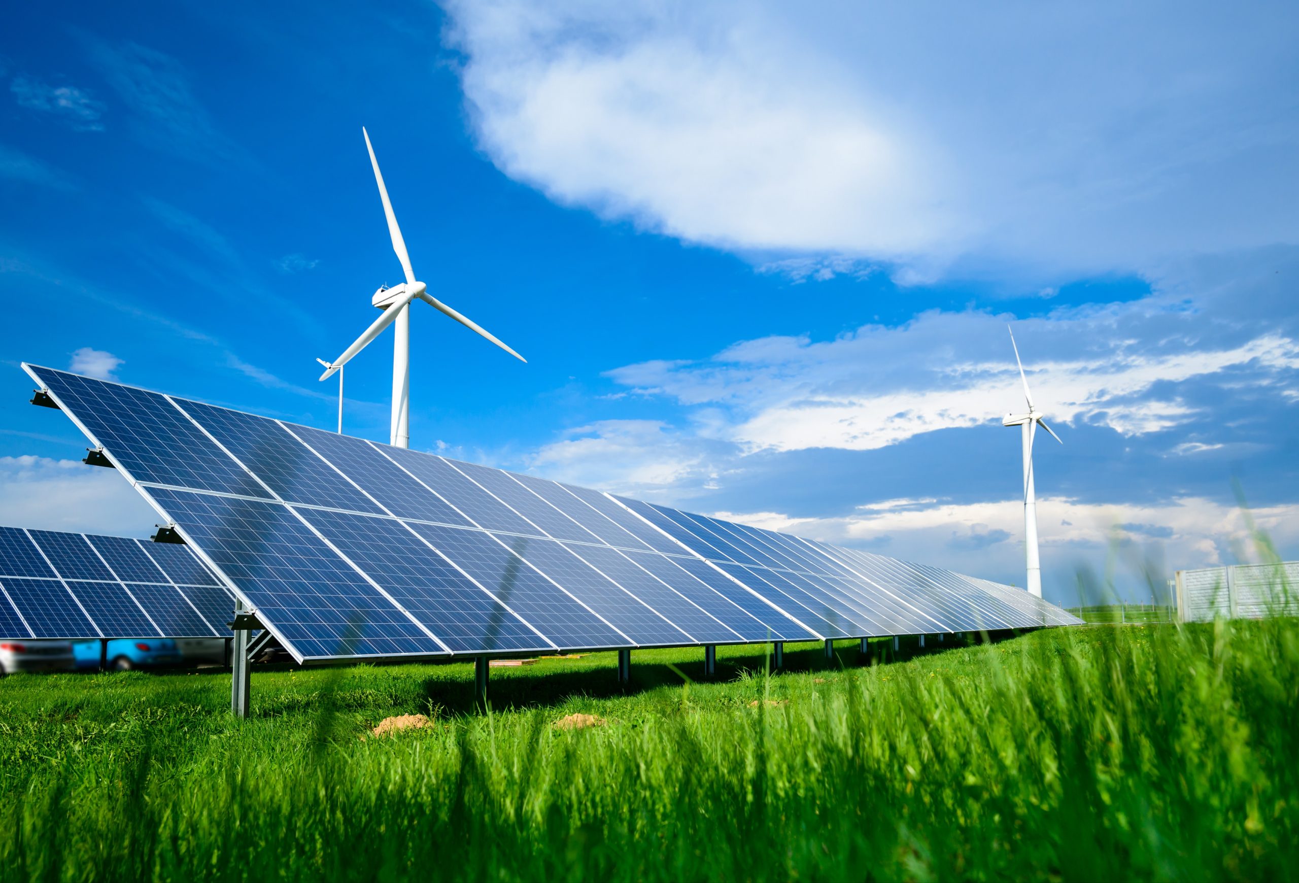 Erneuerbare Energie, Windkrafträder, Sonnenkollektoren in der Natur bei blauem Himmel.